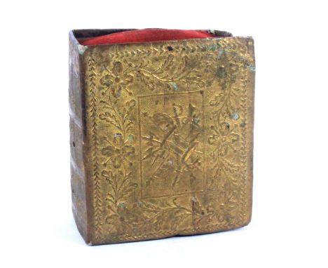 A gilt foil book form pin cushion, the covers with panels of musical and military trophies within floral borders, the 'spine'