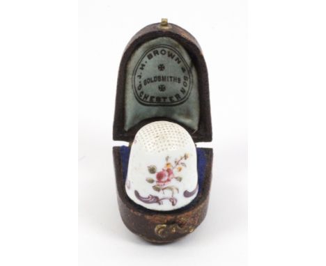 An English 18th Century Staffordshire enamel thimble, the white ground decorated with colourful flowers over a border of purp