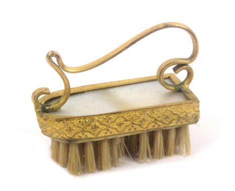 A Palais Royal mother of pearl and gilt metal mounted moustache brush, with scroll handle, 4.4cms.&nbsp; 
