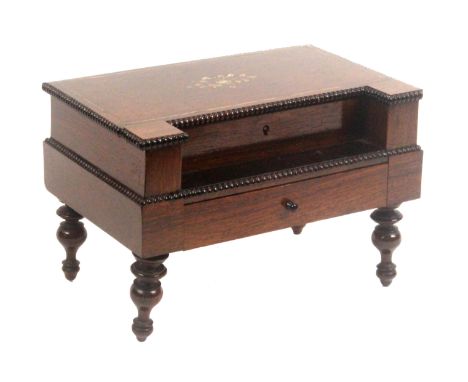 A French rosewood sewing box in the form of a rectangular piano, raised on four turned legs supporting a drawer, below a hing