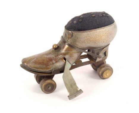 A white metal novelty tape measure/pin cushion in the form of a roller skate, complete printed tape in cms and ins., pin cush