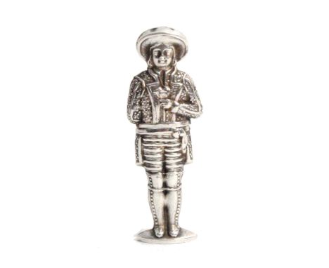 A continental figural silver needle case, in the form of a male in breaches, decorated jacket and hat, a group of playing car