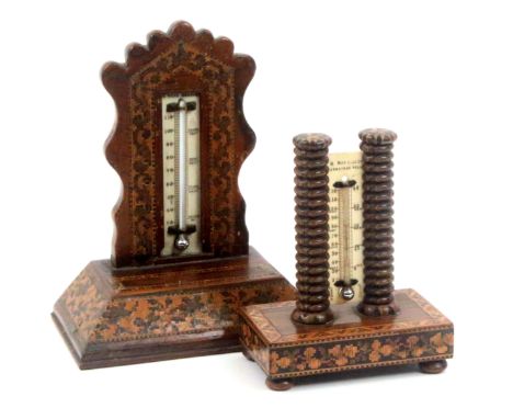 Two Tunbridge ware desk thermometers, one raised on bun feet and mosaic rectangular base supporting a pair of stick ware pill