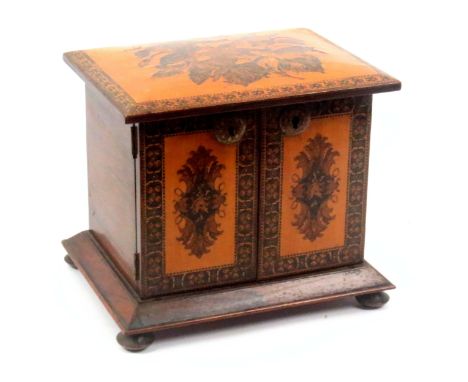 A Tunbridge ware rosewood table cabinet, on four bun feet below a canted rosewood moulding, the front enclosed by a pair of d