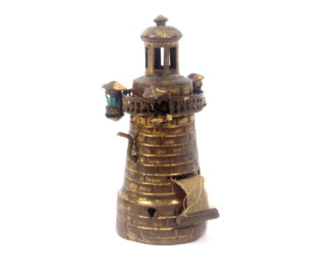 A novelty brass tape measure in the form of a lighthouse, of turret form, the walkway with three subsidiary lights, one lacki