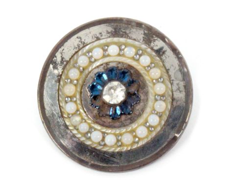 An 18th Century steel button with copper rim, the centre with a paste stone set within a blued flower head within a mother of