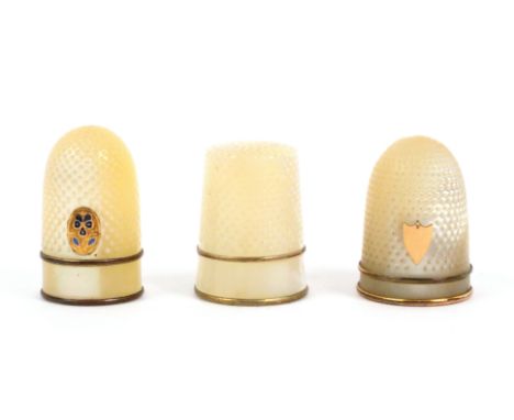 Three mother of pearl thimbles, comprising a Palais Royal example with inset gilt and enamel pansy motif, plain frieze betwee