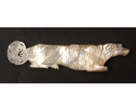 A Palais Royal carved mother of pearl needle case in the form of a dog at rest, curled pierced tails, loss to front legs, 9.8