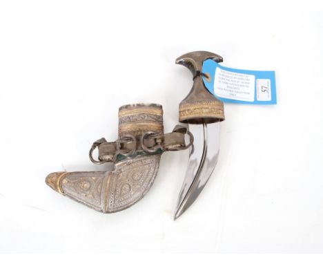 A Middle Eastern Janbiyya dress dagger and sheath, both with white metal embellishment. This item can only be purchased by so