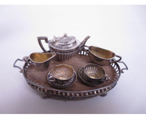 An Edward VII/George V silver miniature Tea Service, viz: Teapot, Sugar Bowl, Jug, two Cups and Saucers, oval gallery Tray, B