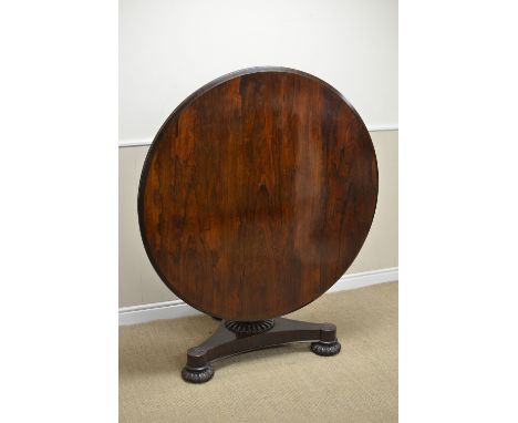 A George IV rosewood Breakfast Table, the tilt-action moulded top with shallow frieze, above reeded and foliate column, with 