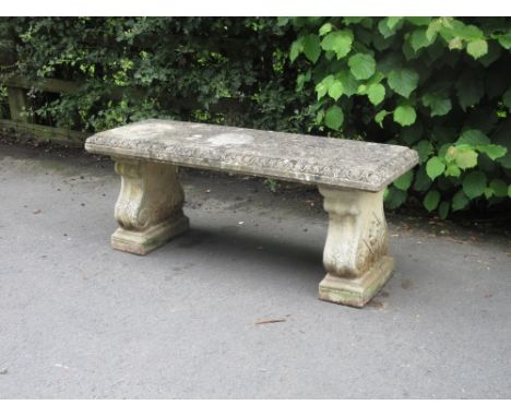 A composition Garden Bench with rectangular seat on shaped supports, 3ft 11in W