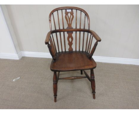 An early 19th Century Windsor Elbow Chair in ash and elm etc, with pierced splat and stick back, solid seat on turned legs un