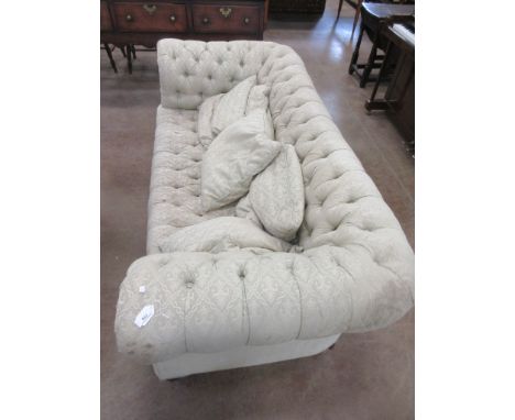 A Victorian button upholstered Chesterfield Settee on turned front supports and casters, 6ft 4in W