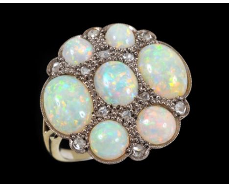 An unusual Opal and Diamond Cluster Ring set seven opal cabochons interspersed with twelve rose-cut diamonds in white gold st