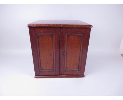 A late 19th/early 20th Century mahogany Coin Cabinet with two door front, fitted with twenety one trays (some trays warped)