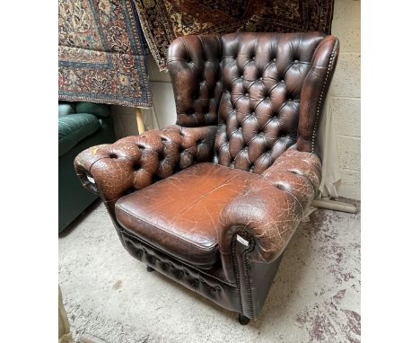 Distressed leather button-back winged armchair 