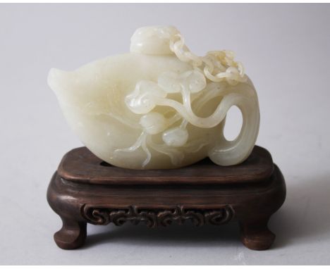 A GOOD CHINESE JADE TEAPOT &amp; HARDWOOD STAND, the teapot with fruit and vine forming the handle, the lid attached with car