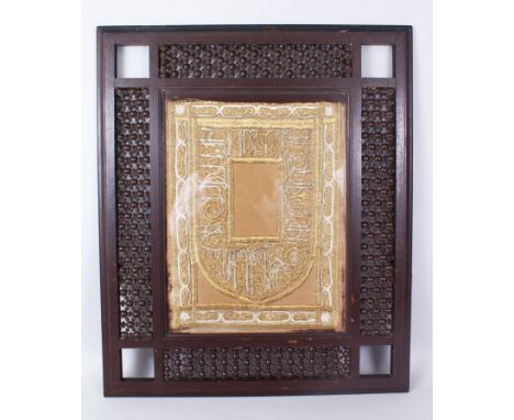 A 19TH CENTURY ISLAMIC OTTOMAN MIHRAB SHAPED TEXTILE PANEL with gilt metal wire embroidery in its original wooden frame, text