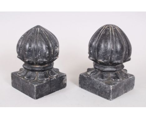 A PAIR OF MOGUL INDIAN CARVED STONE CARPET WEIGHTS on square bases, 16cm high.