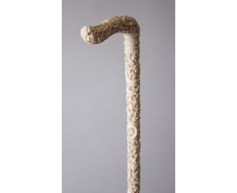 A GOOD 19TH CENTURY CHINESE CARVED IVORY PARASOL HANDLE, the main body carved in relief with scenes of flora, dragons and pho