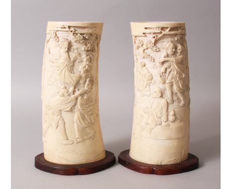 A GOOD PAIR OF JAPANESE MEIJI PERIOD CARVED IVORY TUSK VASES, the tusk sections deeply carved in relief to depict scenes of g