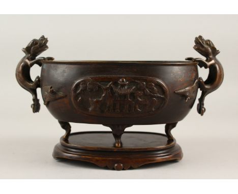 A 19TH CENTURY CHINESE BRONZE CENSER ON STAND, the censor with twin lion dog handles, with on laid moulded birds to each side