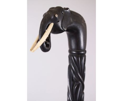 A CEYLONESE CARVED EBONY ELEPHANT HANDLE WALKING STICK, 88cm long.