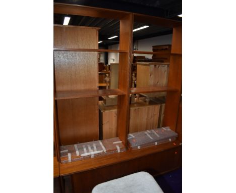 A vintage teak G plan shelf unit having open shelves over sliding door base, width approx. 153cm