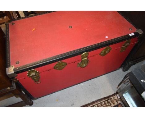 A vintage travel trunk, finished in red