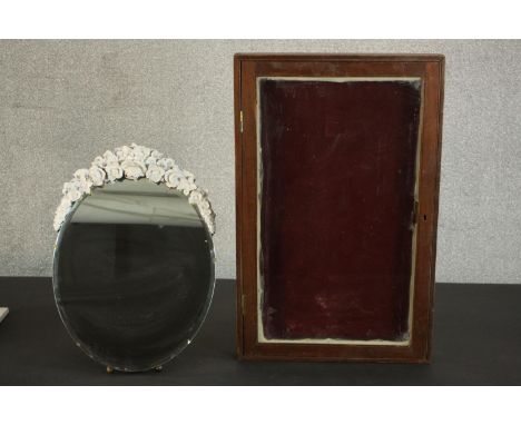 A barbola mirror, of circular form with a bevelled edge, the frame with white painted flowers on an easel stand, together wit