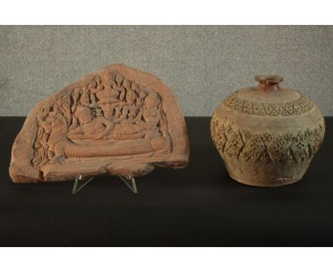 A relief clay tablet depicting Indian deities along with a ceramic vase with incised geometric design. H.23 Dia.24cm. (larges