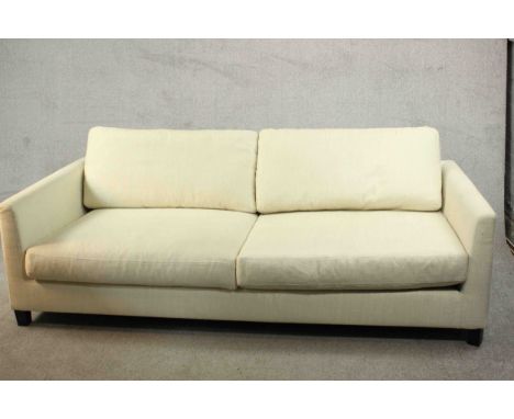 Meridiani, Italy; a contemporary three seater sofa with loose back and seat cushions, upholstered in cream fabric and raised 