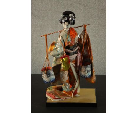 A Vintage Japanese Geisha doll in kimono and traditional dress, ceramic face, carrying a yoke with two water buckets. H.43 W.