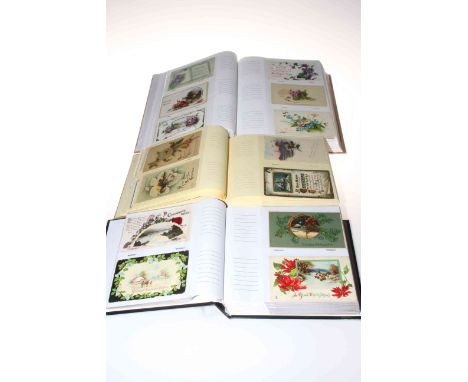 Three postcard albums housing vintage Christmas and New Year greetings postcards, approximately 700 cards.