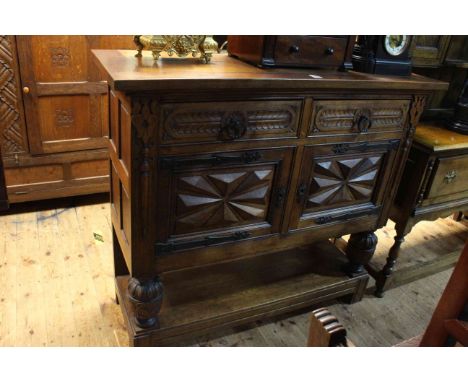 Carved oak buffet cabinet having two drawers above two cupboard doors and undershelf, 111cm by 125cm by 45cm.