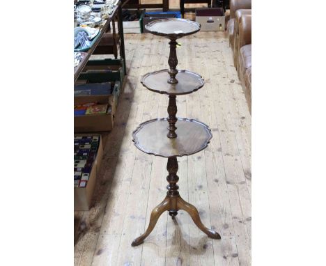 Mahogany three tier stand having three circular shaped scalloped shelves on tripod base, 105cm tall.