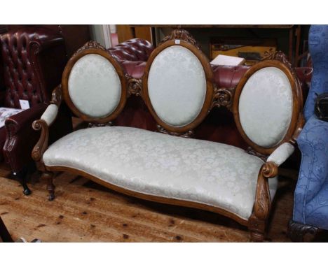 Victorian walnut triple oval panel back settee with serpentine front seat.