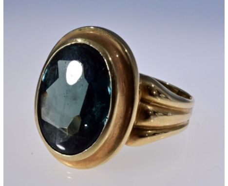Opulenter Ring aus 585er Gelbgold. Ringschultern dreisträngig miteinander verbunden, mittig ein sehr großer, grüner, geschlif