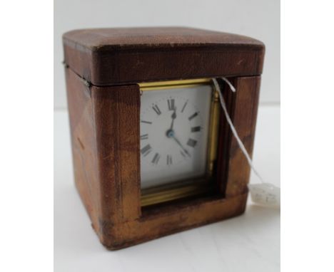 A 19TH CENTURY FRENCH CARRIAGE CLOCK, brass frame with bevelled glass panels, white enamel dial with Roman numerals, in leath
