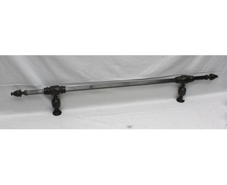 AN ANTIQUED BRASS RANGE POLE, for pans, square section with ace of diamond wall fittings and finial ends, 141cm long 