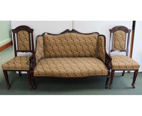 AN EDWARDIAN CARVED MAHOGANY SHOW WOOD FRAMED SALON SOFA together with a pair of single chairs, machine tapestry upholstered 