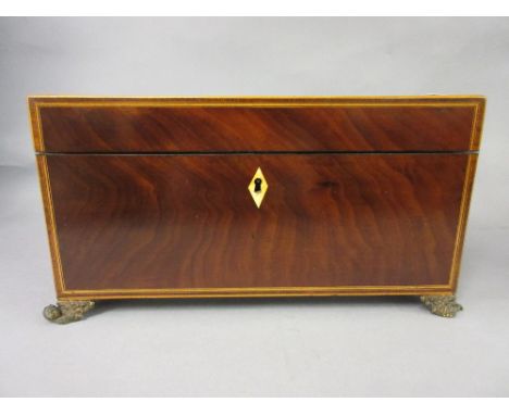 Regency mahogany crossbanded and line inlaid rectangular tea caddy, the hinged cover enclosing a fitted interior on gilt bras