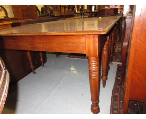 Rectangular mahogany four leaf three section dining table, the moulded top above ring turned tapering supports with brass cap