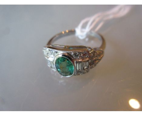 Art Deco style emerald and diamond dress ring, the central oval emerald of approximately 0.5ct surrounded by baguette and bri