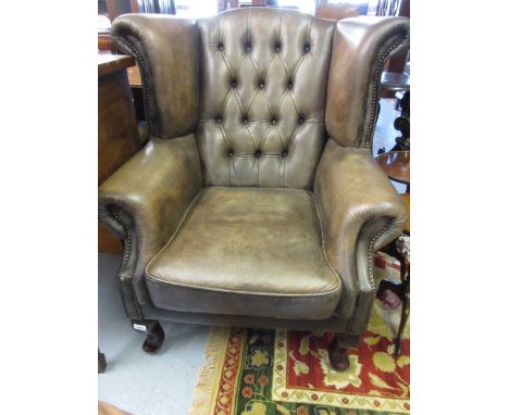 Pair of later stained brown leather button upholstered wing armchairs with loose cushions on cabriole front supports