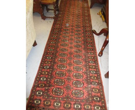 Indo Persian runner of Bokhara design with a twin row of gols on a pink ground