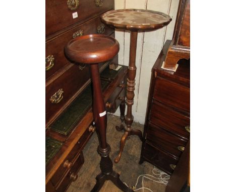 Reproduction mahogany tripod torchere together with a similar pedestal torchere