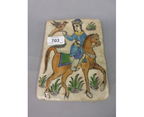 Persian relief decorated and painted pottery tile depicting a huntsman and hawk