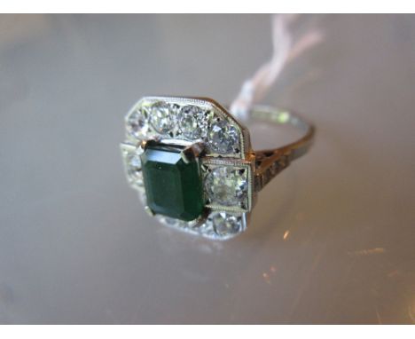 Art Deco style emerald and diamond ring of irregular octagonal form, the central emerald of approximately 1.2ct within a diam